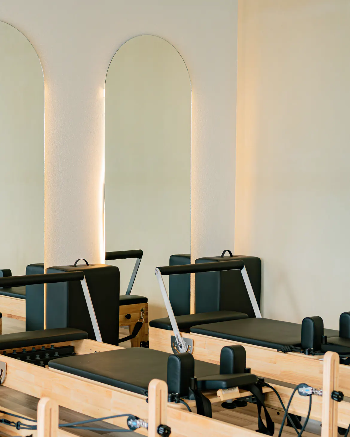 Sala de un estudio de Pilates con espejos y un arco iluminado por la noche