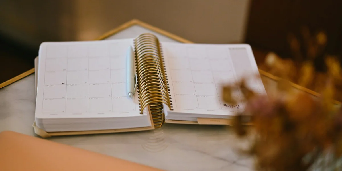 Una agenda de espiral abierta sobre una mesa de mármol